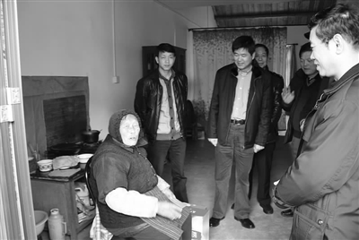 镇党委书记沈玉明与村干部一起走访百岁老人