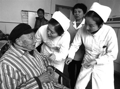 图为护士们与老年病人聊天.